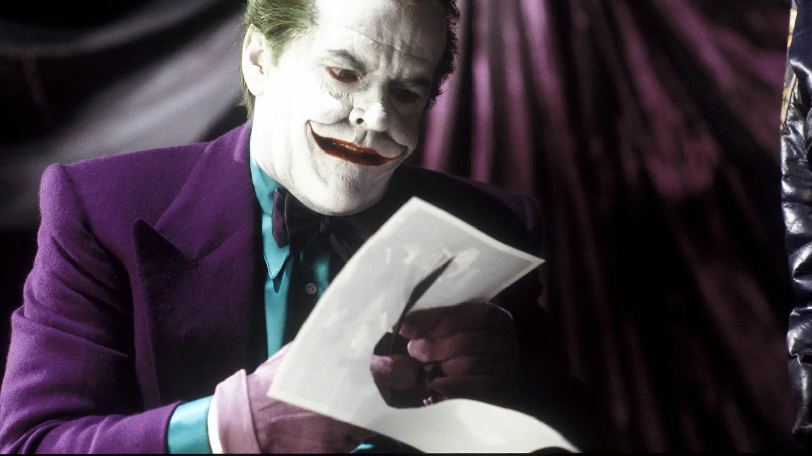Jack Nicholson como Coringa em Batman, com traje roxo e carta de baralho.