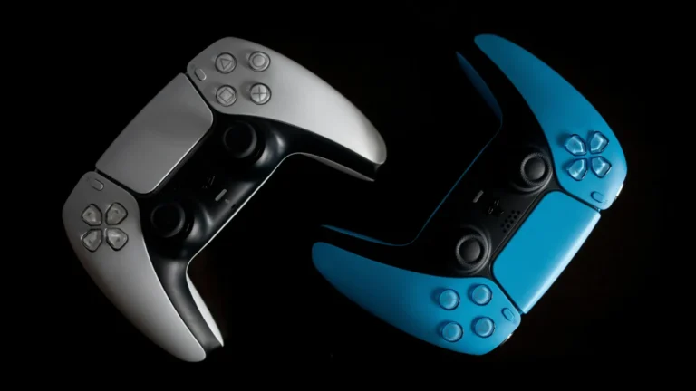 Dois controles DualSense, um claro e outro azul, sobre fundo escuro