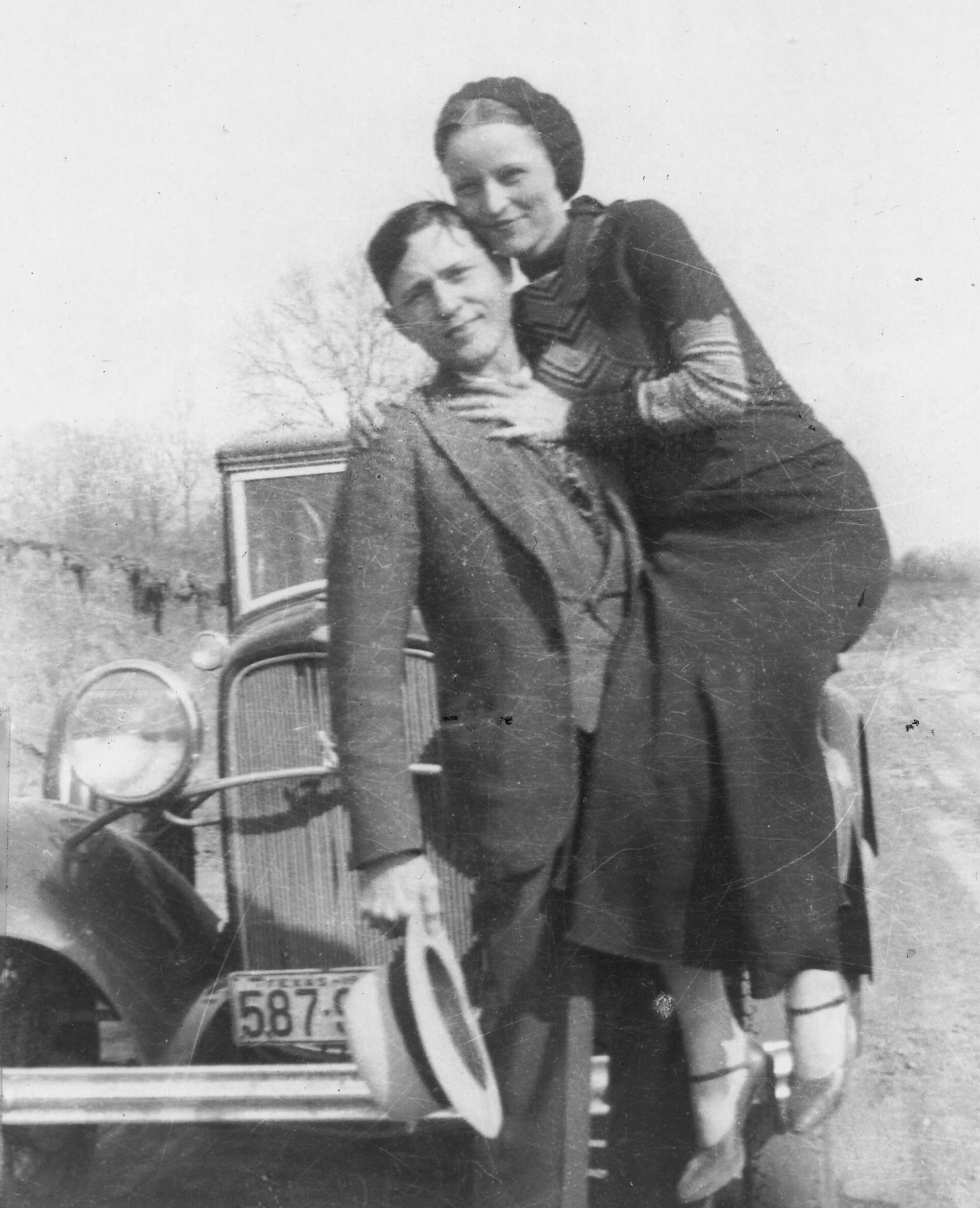 Bonnie Parker e Clyde Barrow posam diante de um Ford V8