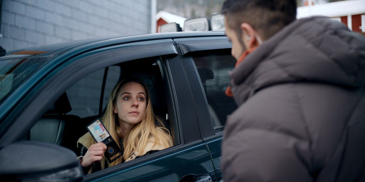 Hanna mostra distintivo em Os Assassinatos de Åre