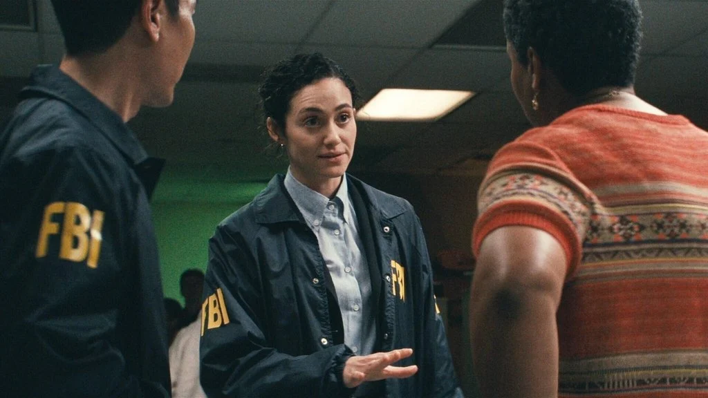 Emmy Rossum como a agente Alice Black conversando com integrantes do FBI na série Fúria, do Disney+.