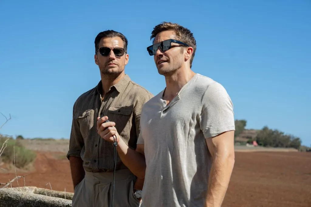 Henry Cavill e Jake Gyllenhaal apontam armas durante uma missão em Na Zona Cinzenta.