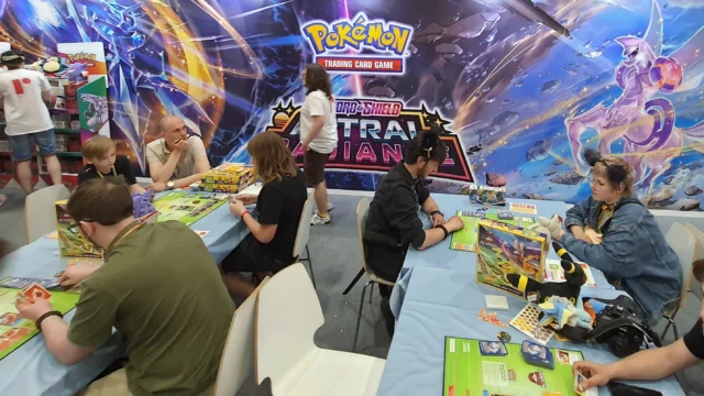 Jogadores de Pokémon TCG negociam e jogam cartas em evento