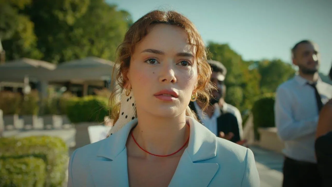 Seray Kaya como Elif, com expressão séria e blazer azul-claro, em Sol da Minha Vida.
