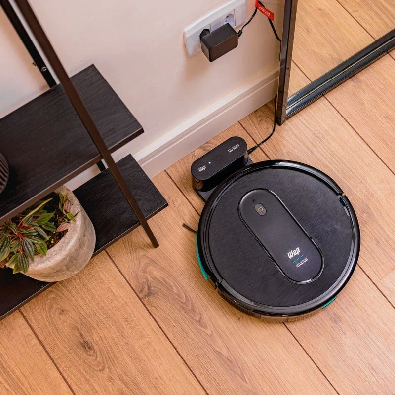 WAP Robot W400 preto estacionado em uma base compacta de recarga sobre piso de madeira