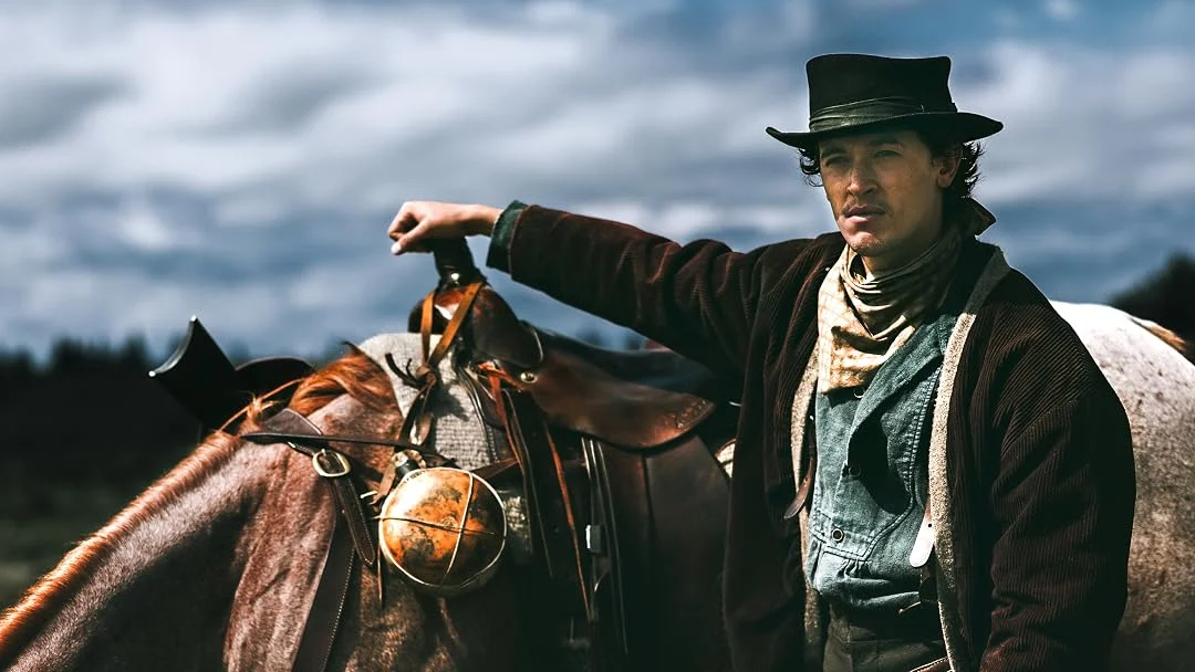 Tom Blyth como Billy the Kid ao lado de um cavalo na série do Prime Video