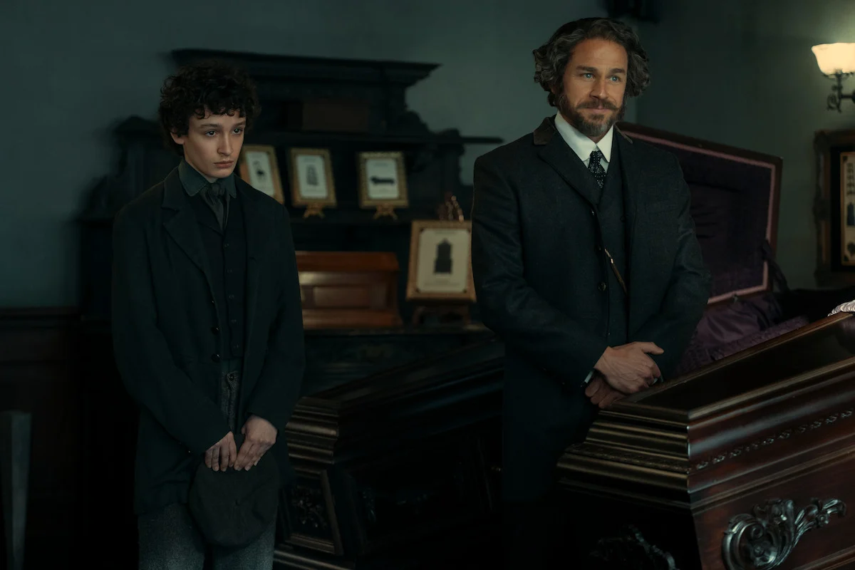 Charlie Hunnam como Andrew Borden, à direita, ao lado de Oliver Spenceman em uma cena de velório