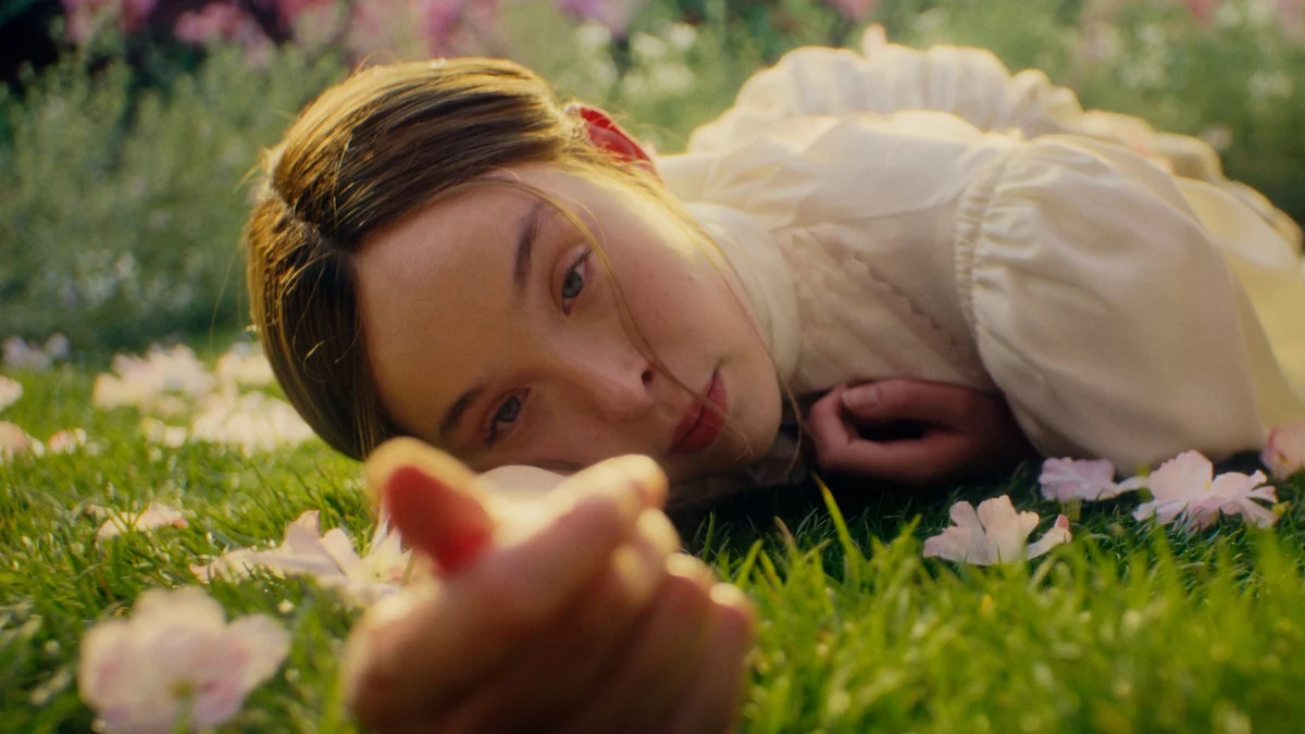 Ella Beatty como Lizzie Borden, deitada entre flores em cena da quarta temporada de Monstro