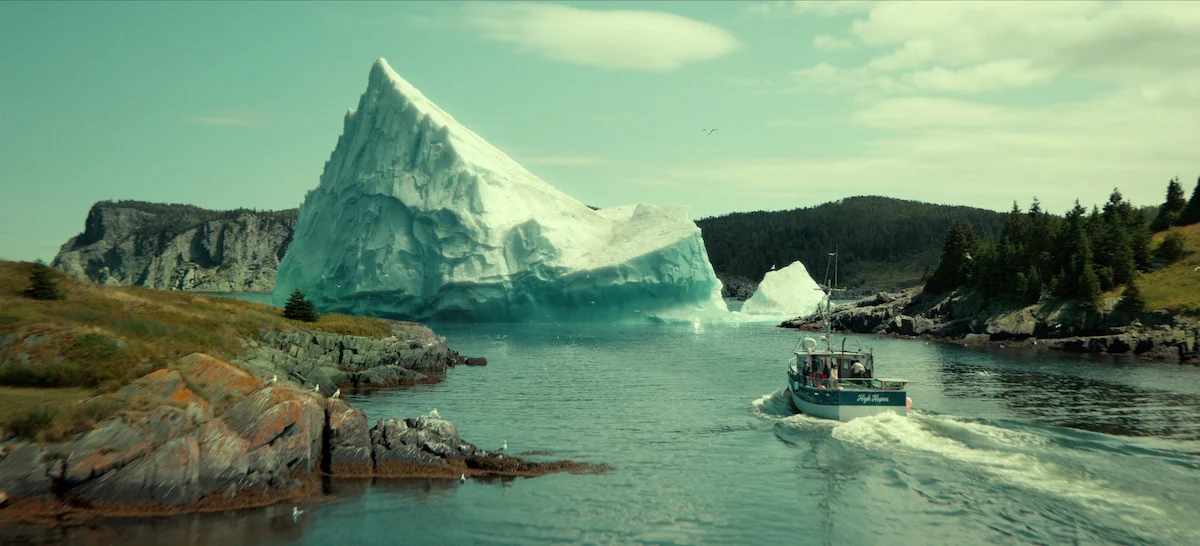 Barco de pesca navegando diante de um enorme iceberg em Profundezas da Netflix