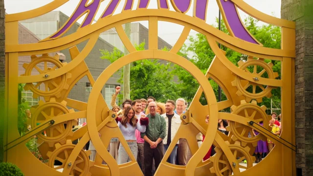 Participantes de Wonka O Bilhete Dourado diante dos portões da fábrica de chocolate