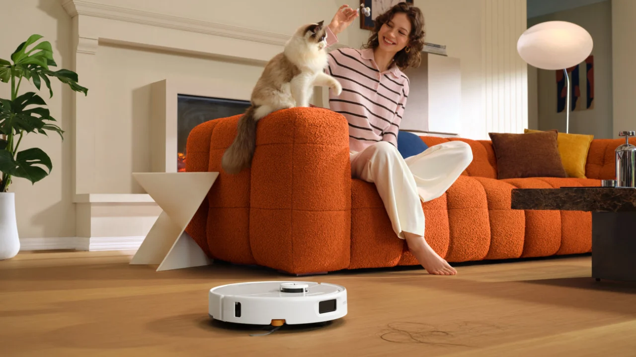 Roborock Qrevo 2 Pro branco limpando o piso de uma sala com um gato ao fundo