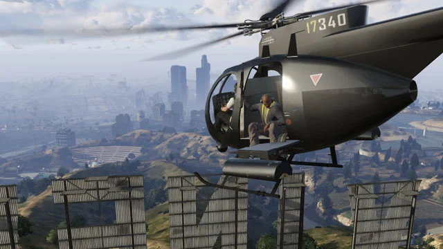 Personagens de GTA Online voam de helicóptero sobre o letreiro de Vinewood e Los Santos.
