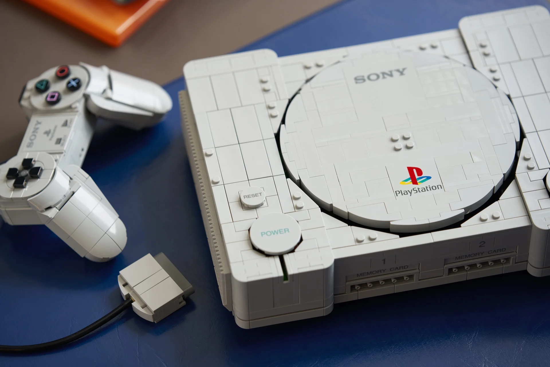 Detalhes da tampa, logo, botão Power e controle do LEGO PlayStation