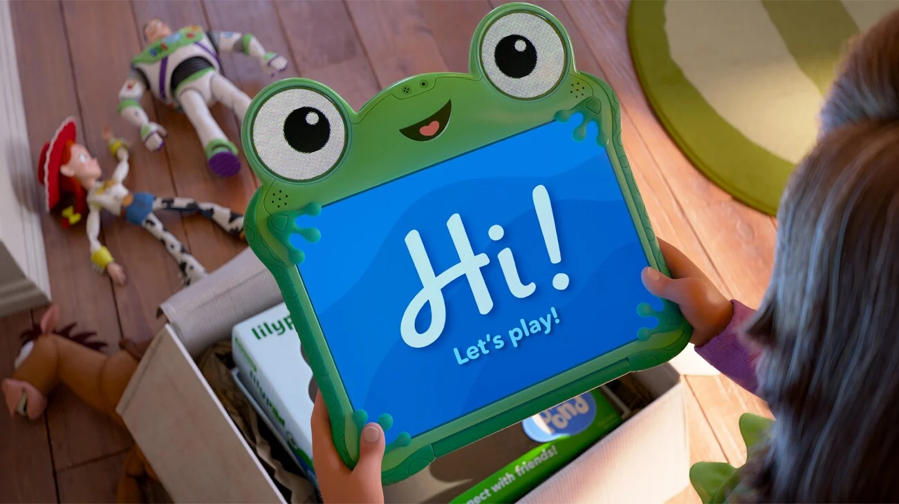 Bonnie segura o tablet Lilypad enquanto Woody e Buzz aparecem ao fundo