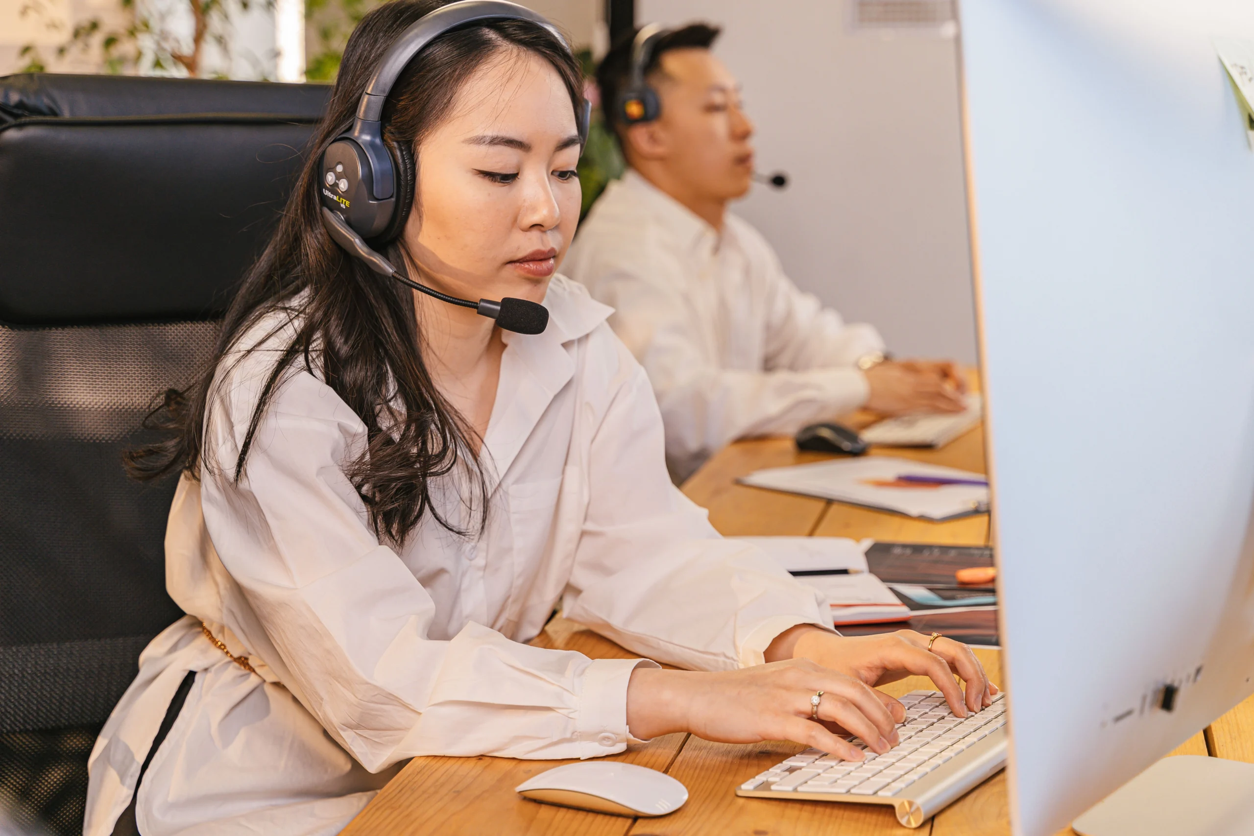 Profissionais trabalhando com headsets em uma central de atendimento