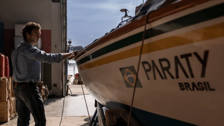 Filipe Bragança observa a embarcação utilizada nas filmagens de 100 Dias durante preparação para interpretar Amyr Klink