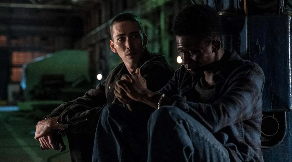 Scott Eastwood como Riggin conversa com Tyrese Gibson como Mercer dentro da fábrica em 1992