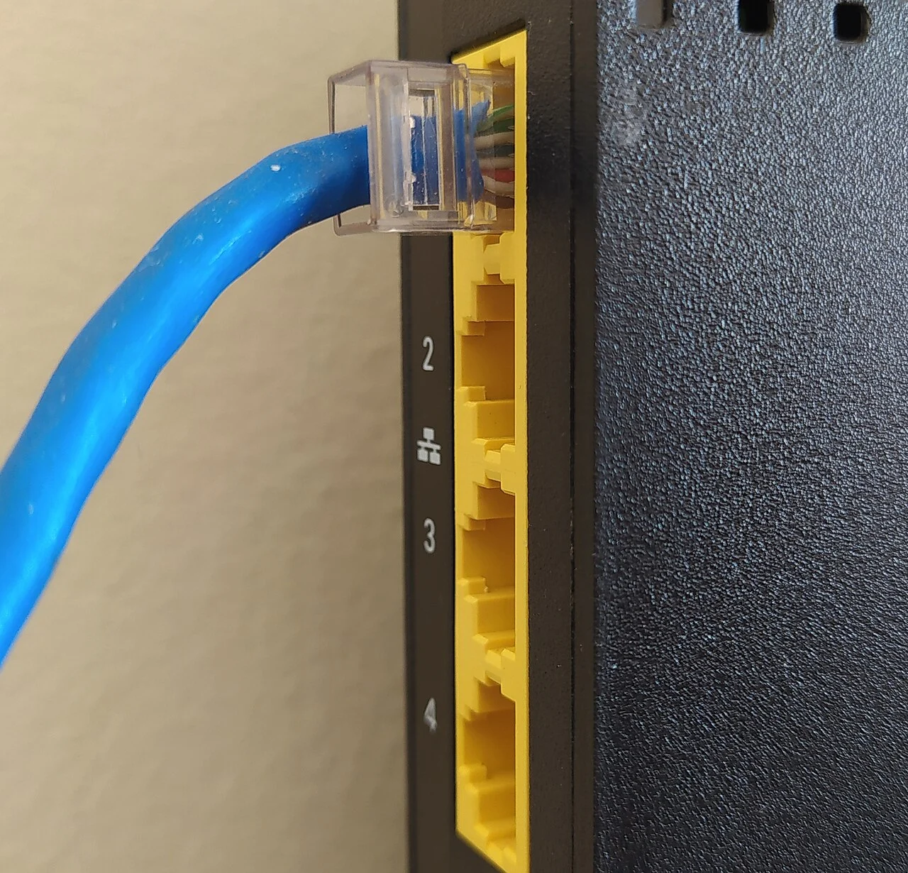 Conector de cabo Ethernet azul conectado à entrada de rede de um roteador