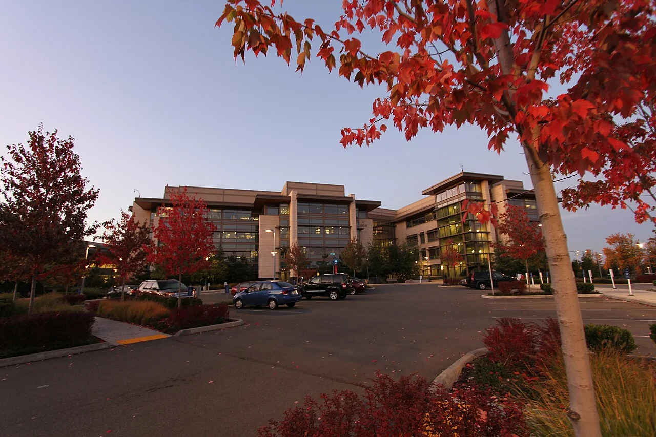 Prédios de escritórios do West Campus da Microsoft em Redmond ao entardecer, com árvores avermelhadas