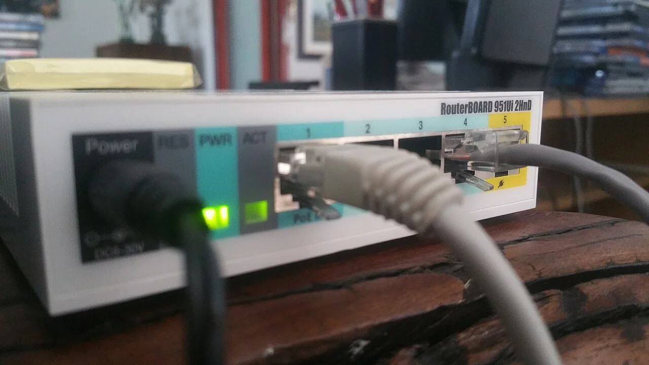 Roteador de rede conectado a cabos Ethernet, com luzes de atividade acesas