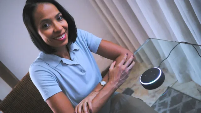 Pessoa utilizando um Amazon Echo Dot em uma residência para controlar dispositivos inteligentes