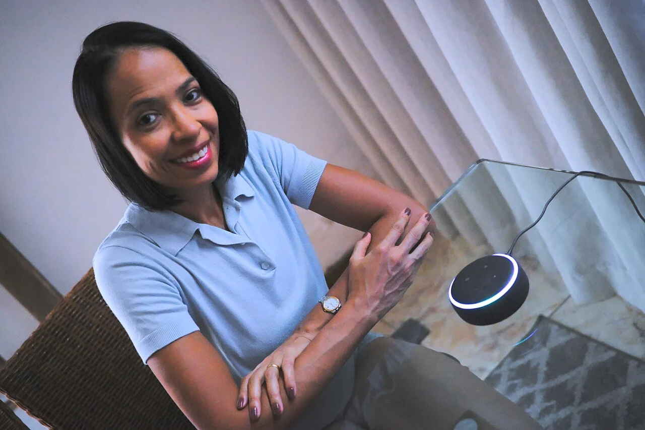 Pessoa utilizando um Amazon Echo Dot em uma residência para controlar dispositivos inteligentes