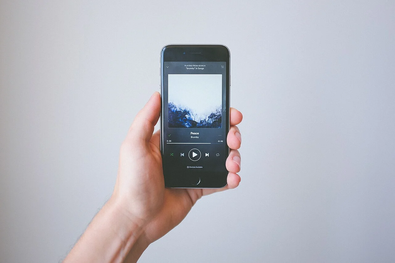 Pessoa segura telefone com aplicativo de música Spotify em fotografia de 2017