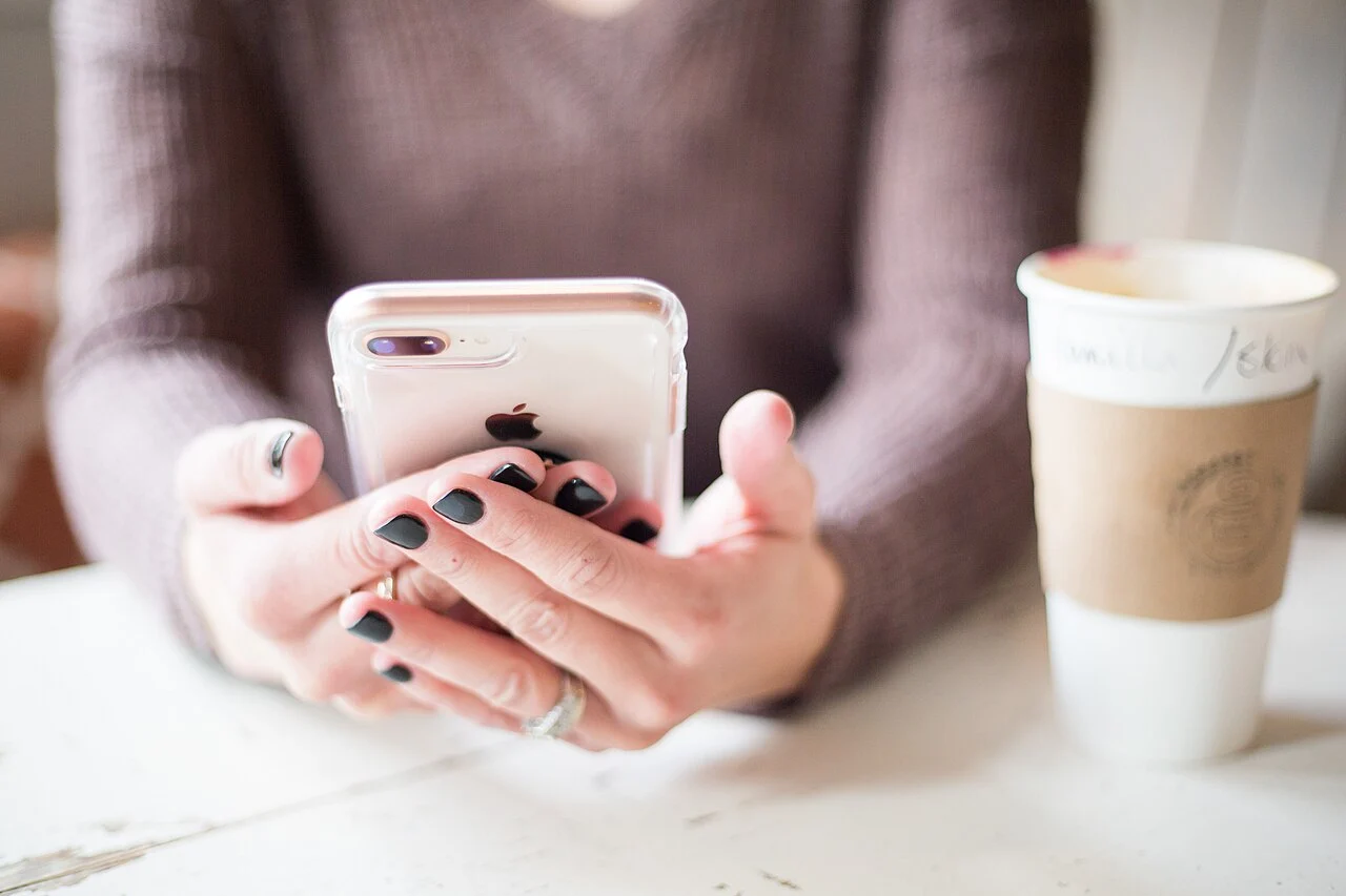 Pessoa utilizando um smartphone para consultar informações de compras e promoções