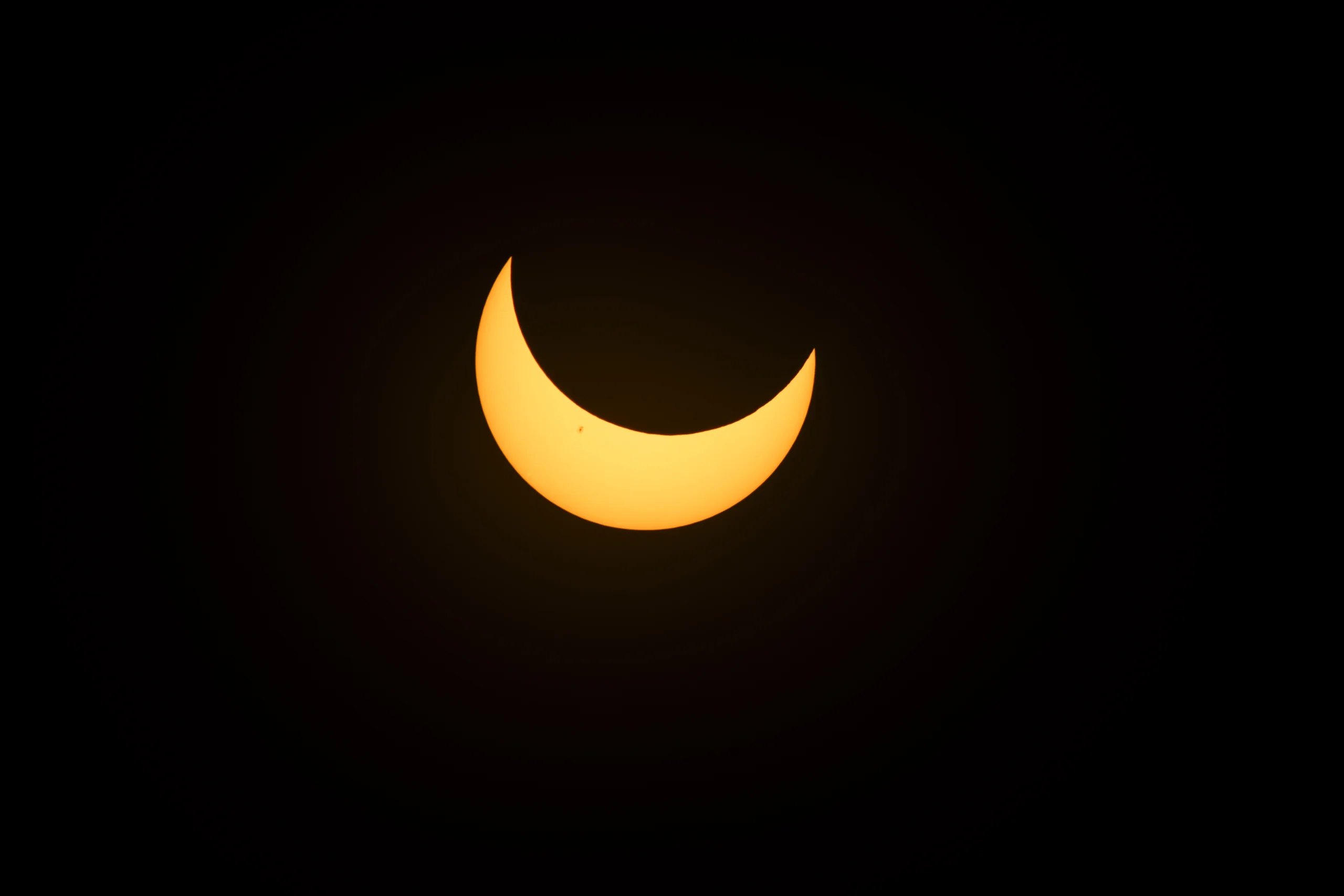 Fotografia da NASA de um eclipse solar parcial com o Sol em forma de crescente amarelo sobre o fundo escuro