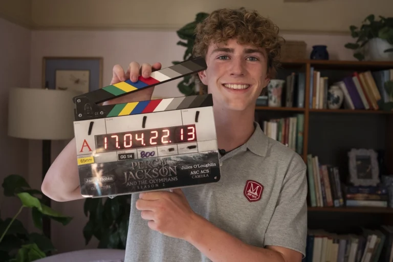 Walker Scobell segura uma claquete da segunda temporada de Percy Jackson nos bastidores