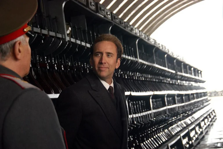 Nicolas Cage como Yuri Orlov diante de uma parede de armas em cena de O Senhor das Armas