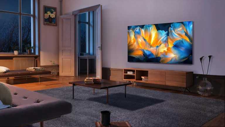 Imagem de divulgação da TCL C6K instalada na parede de uma sala, com flores azuis e amarelas na tela
