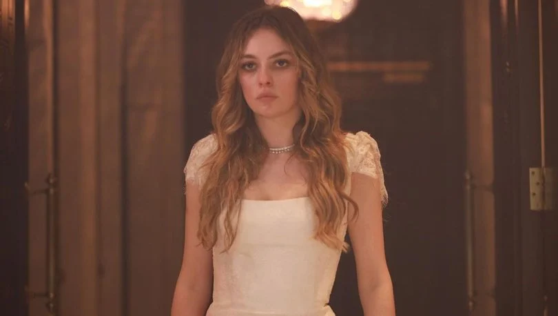 Melis Sezen como Deva em Gülcemal, vestindo roupa branca em uma cena interna