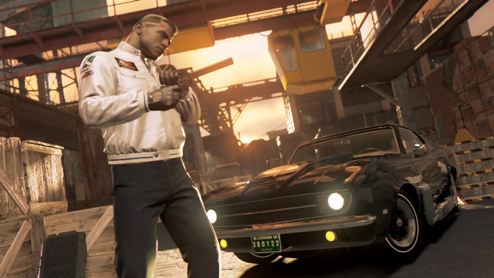 Lincoln Clay verifica sua arma ao lado de um carro clássico em uma área industrial de Mafia III