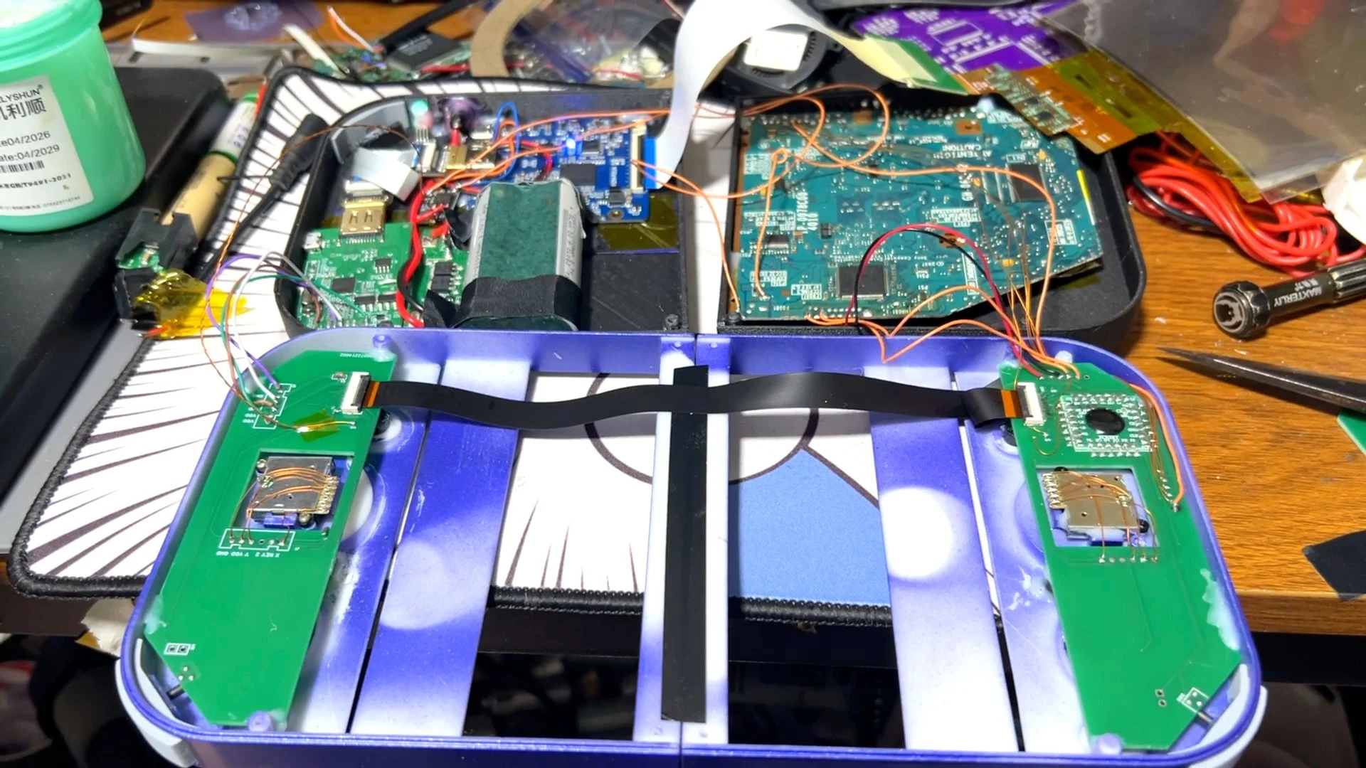 Interior do PlayStation 2 DUO durante a montagem, com placas eletrônicas, fios e estrutura roxa impressa em 3D