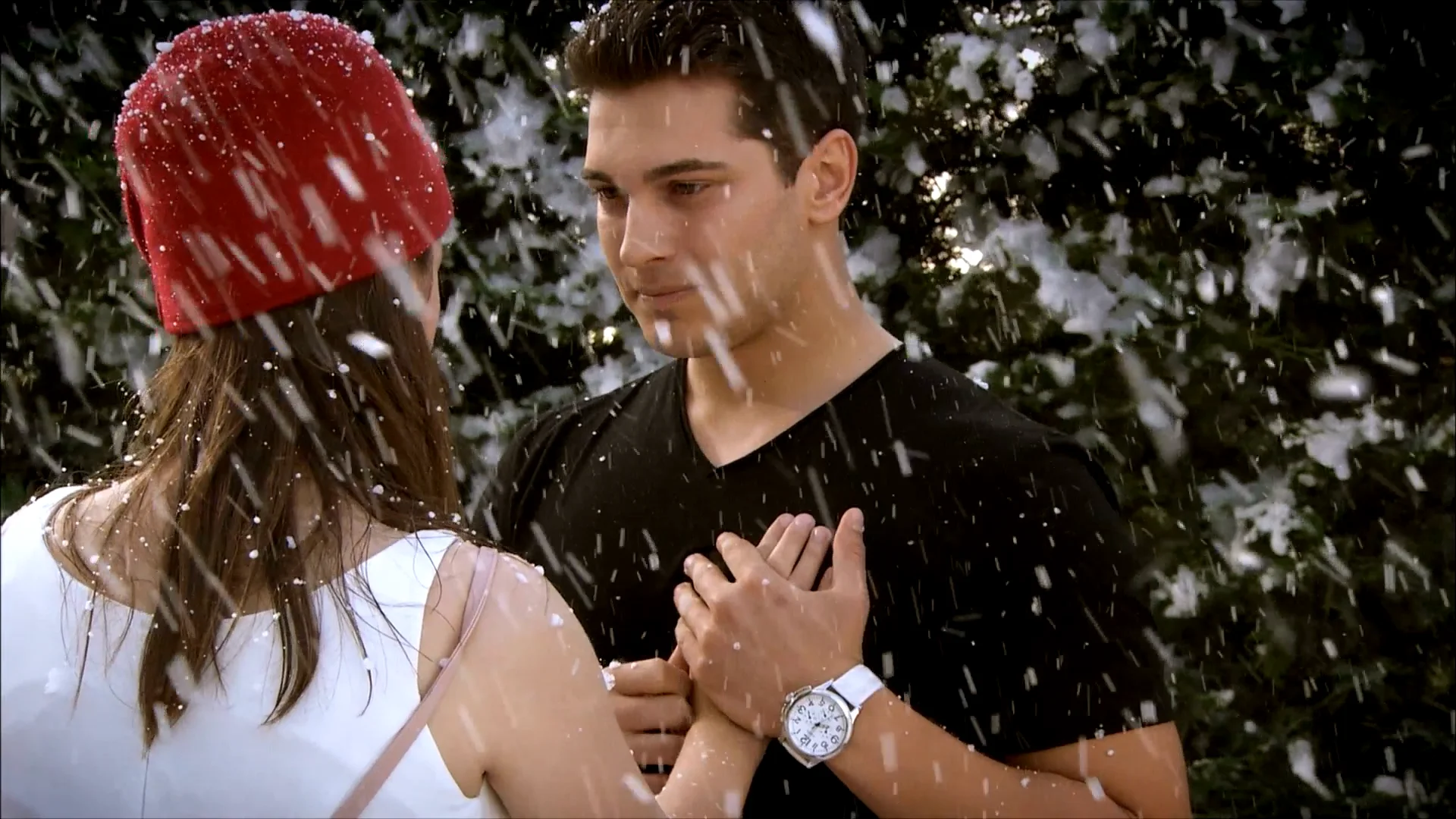 Emir olha para Feriha durante uma cena romântica de O Segredo de Feriha, com flocos de neve ao redor do casal