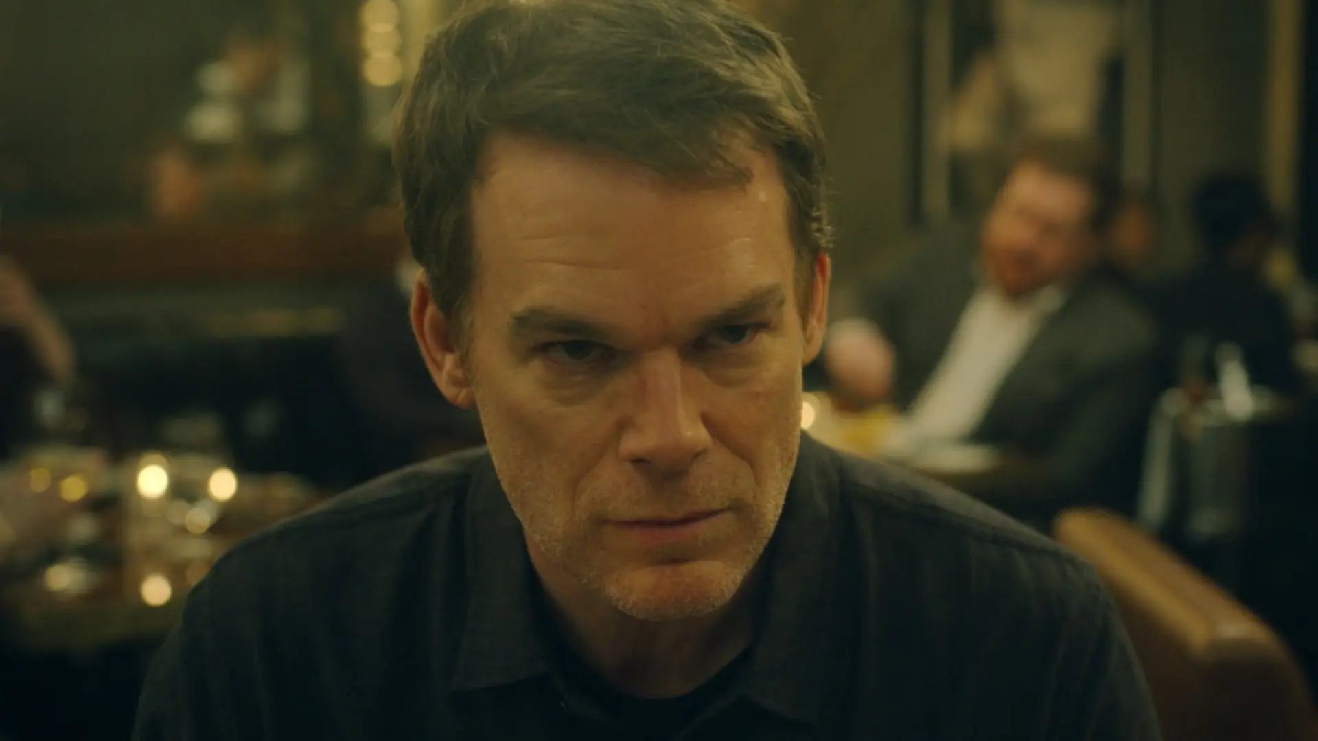 Dexter Morgan interpretado por Michael C. Hall sentado em um restaurante em Nova York