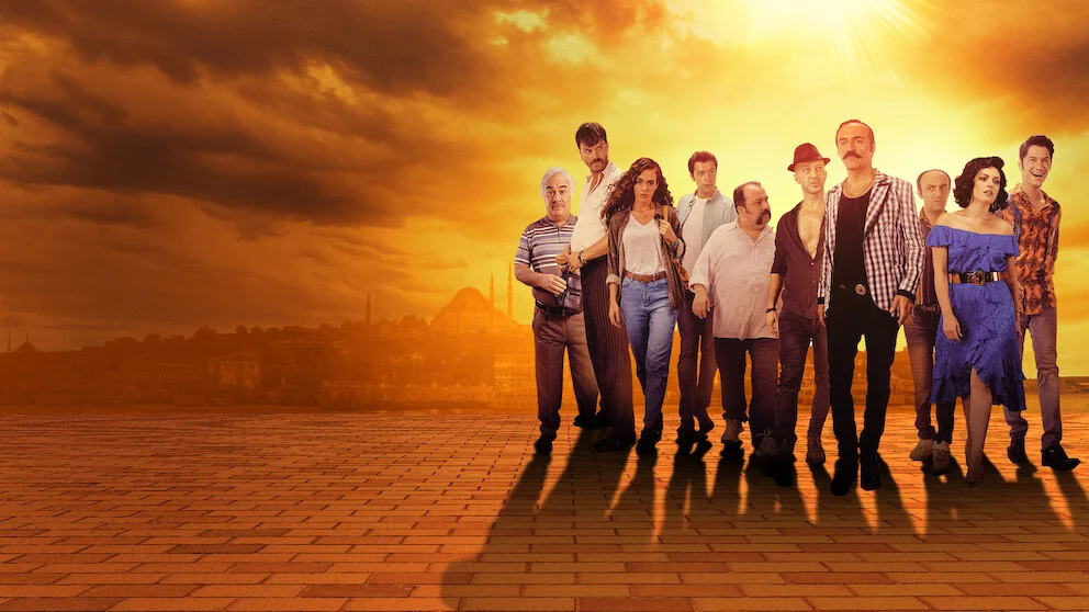 Cartaz horizontal do filme turco Organize İşler: Sazan Sarmalı, de 2019, com o elenco reunido diante de um cenário alaranjado de Istambul