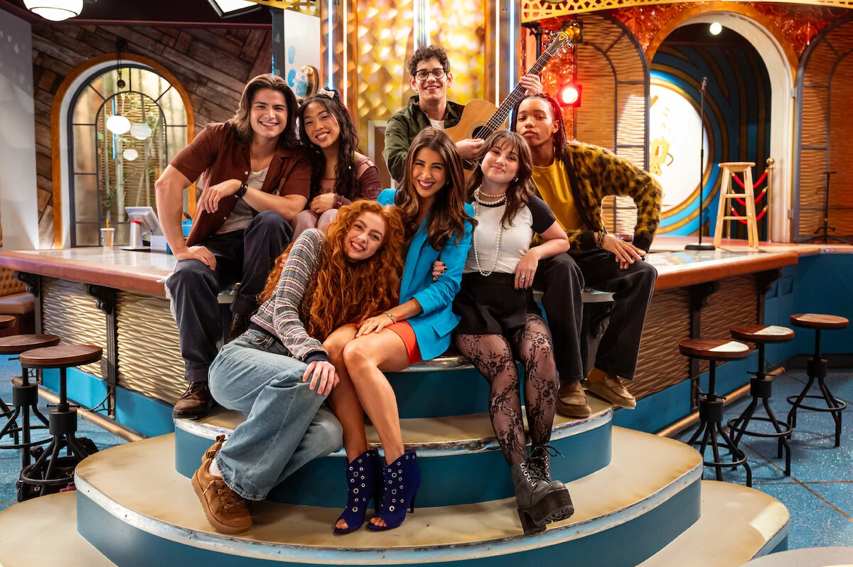 Daniella Monet como Trina Vega ao centro do elenco de Hollywood Arts com novos alunos e Robbie Shapiro