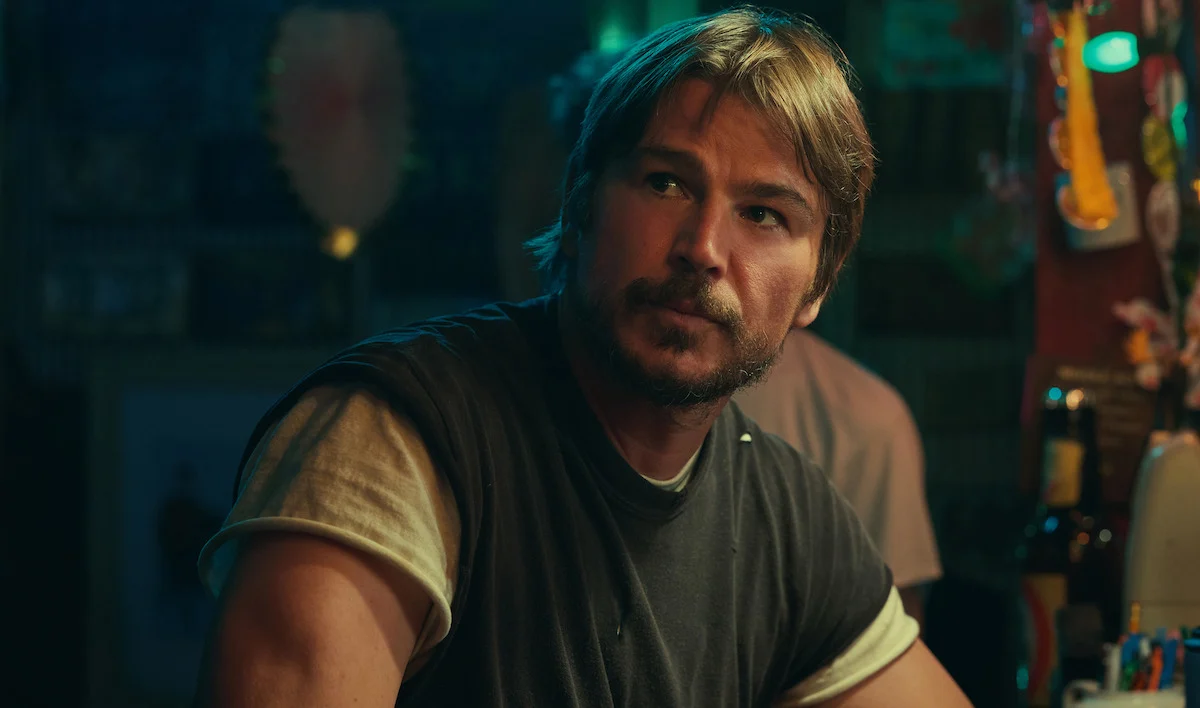Josh Hartnett como Calvin Penney em uma cena de Profundezas, sentado no balcão de um bar
