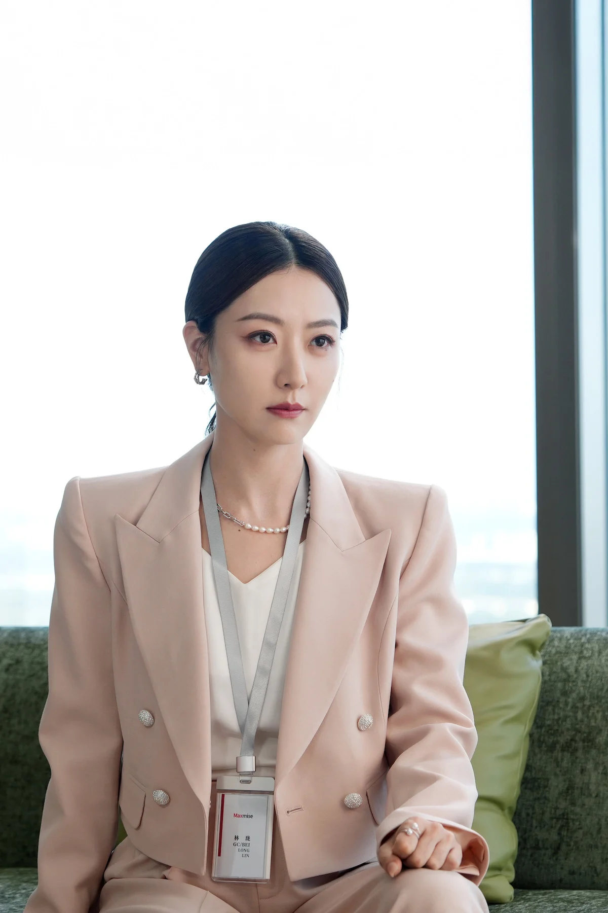 Zhao Jinmai como Xu Chi em Insubstituível, de terno rosa e crachá
