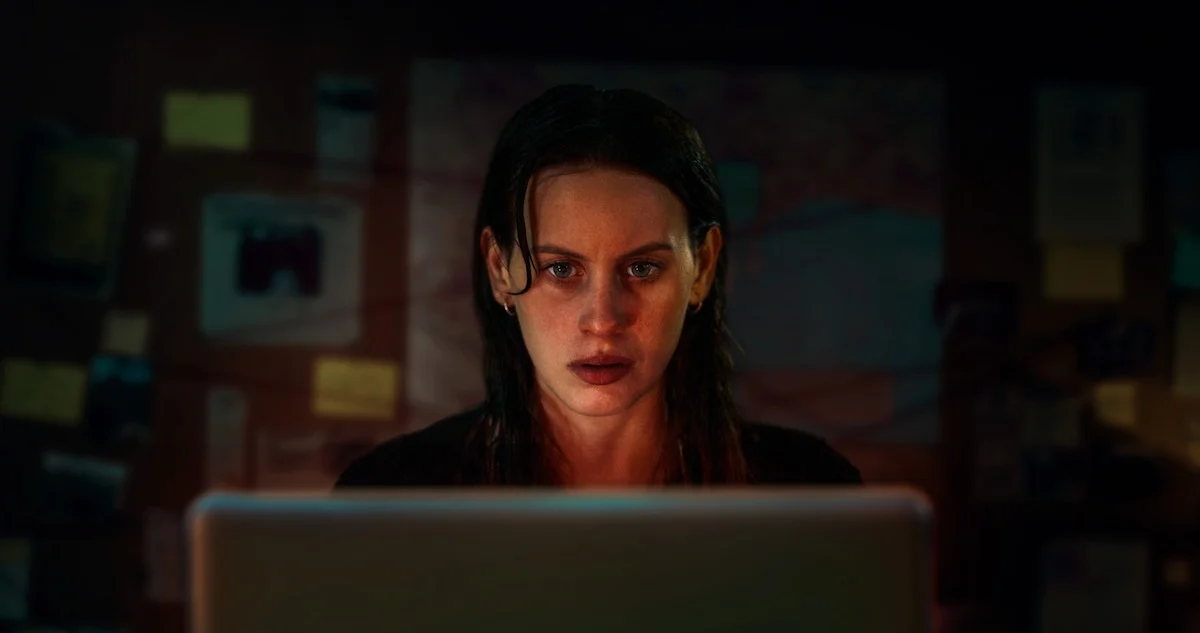 Jornalista Miren investiga um mistério diante do computador na série A Garota na Fita da Netflix