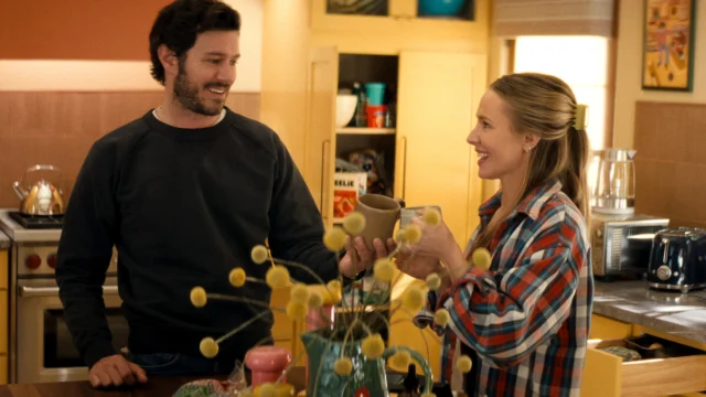 Noah, interpretado por Adam Brody, e Joanne, vivida por Kristen Bell, brindam na cozinha na terceira temporada de Ninguém Quer