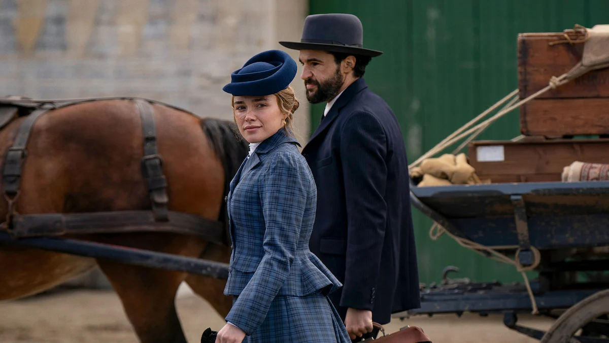 Florence Pugh em A Leste do Éden, com figurino de época ao lado de uma carroça