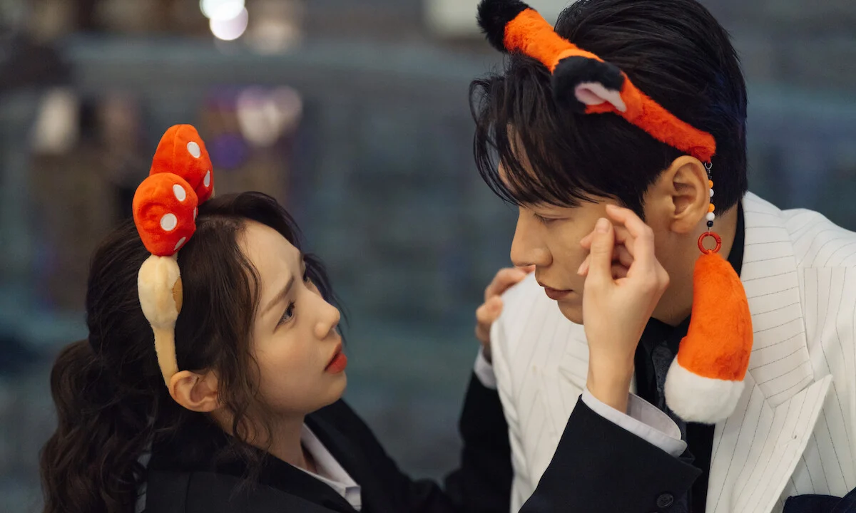 Na Bo-bae toca o rosto de Baek Ho-rang durante um passeio usando acessórios de fantasia