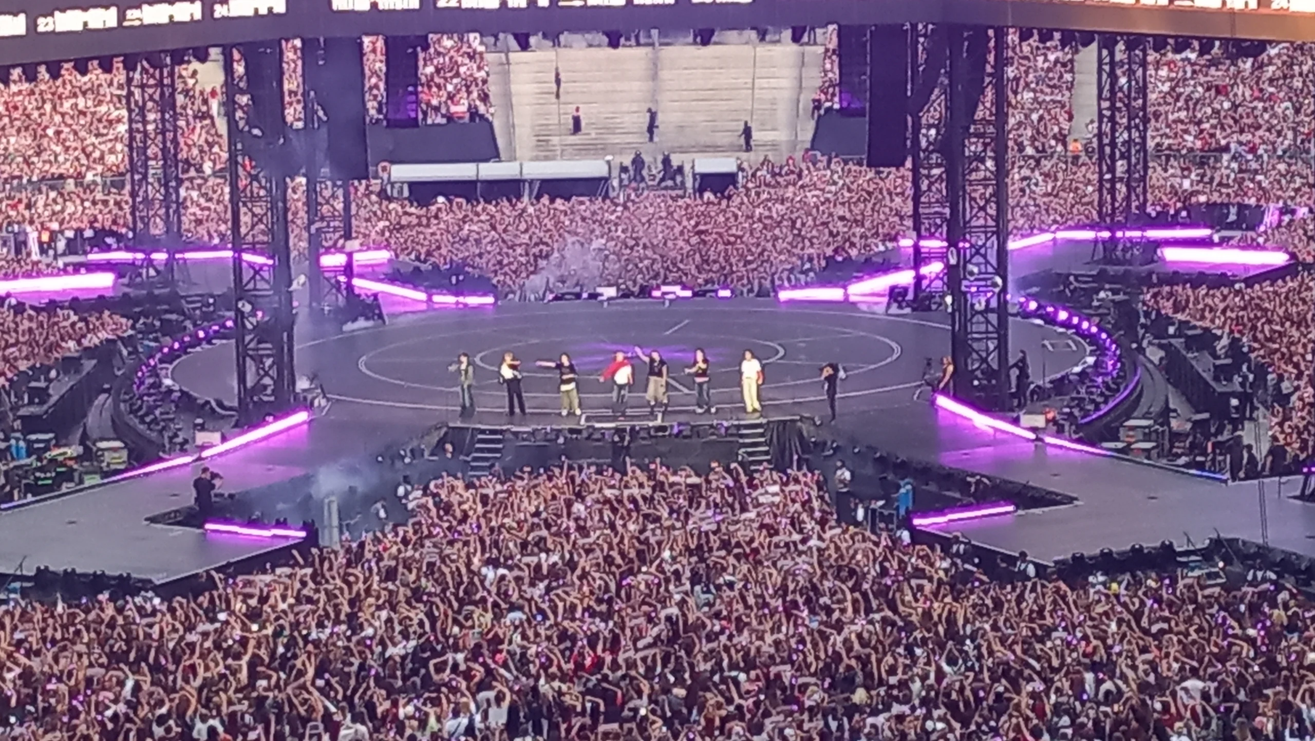 Sete integrantes do BTS no palco diante de milhares de fãs durante a turnê ARIRANG em Paris, em julho de 2026