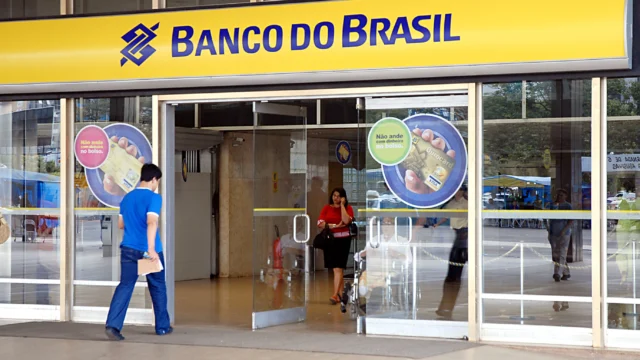 Fachada de uma agência do Banco do Brasil com letreiro amarelo e azul