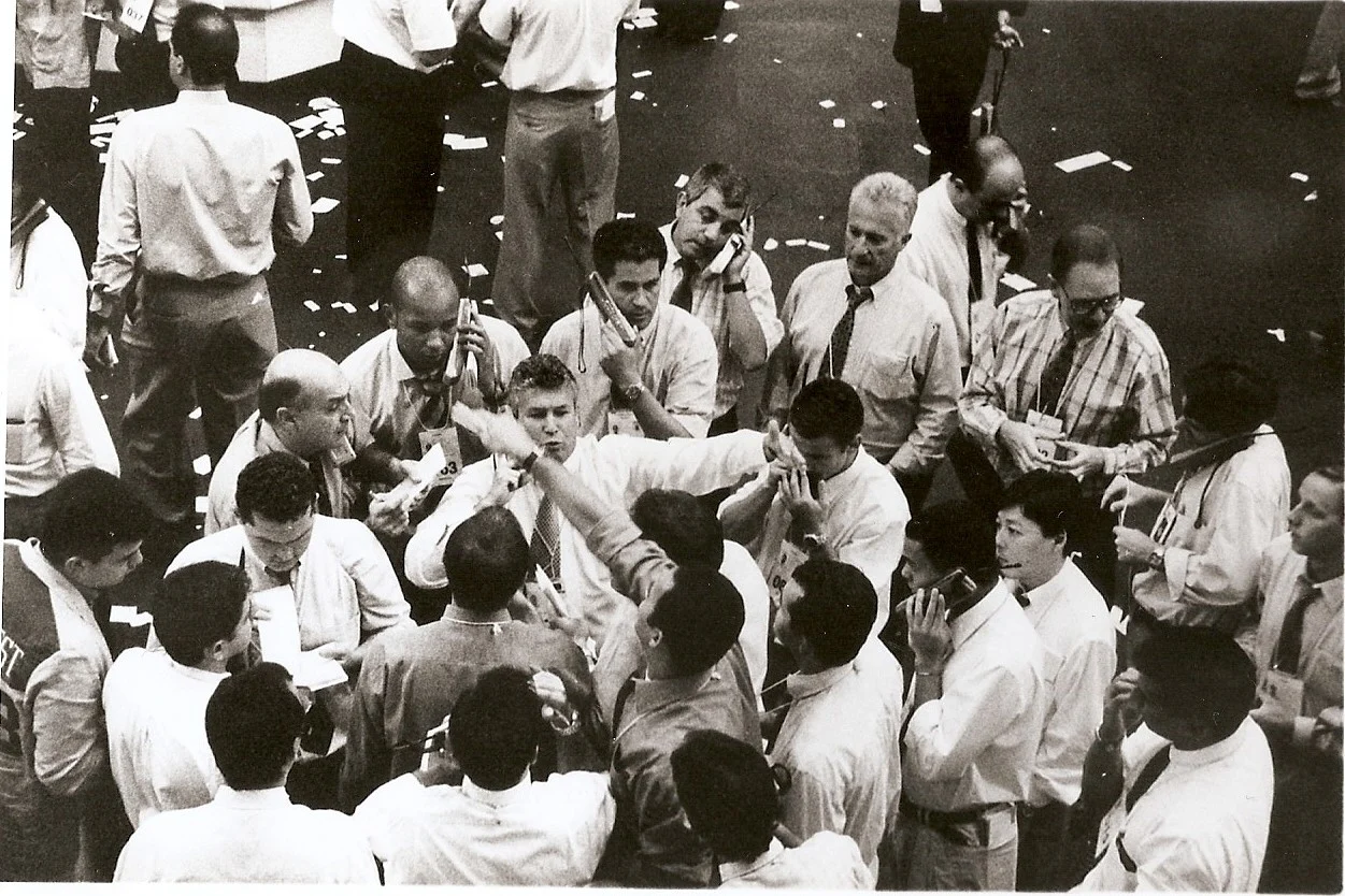 Fotografia histórica em preto e branco com operadores de mercado em movimentado pregão presencial