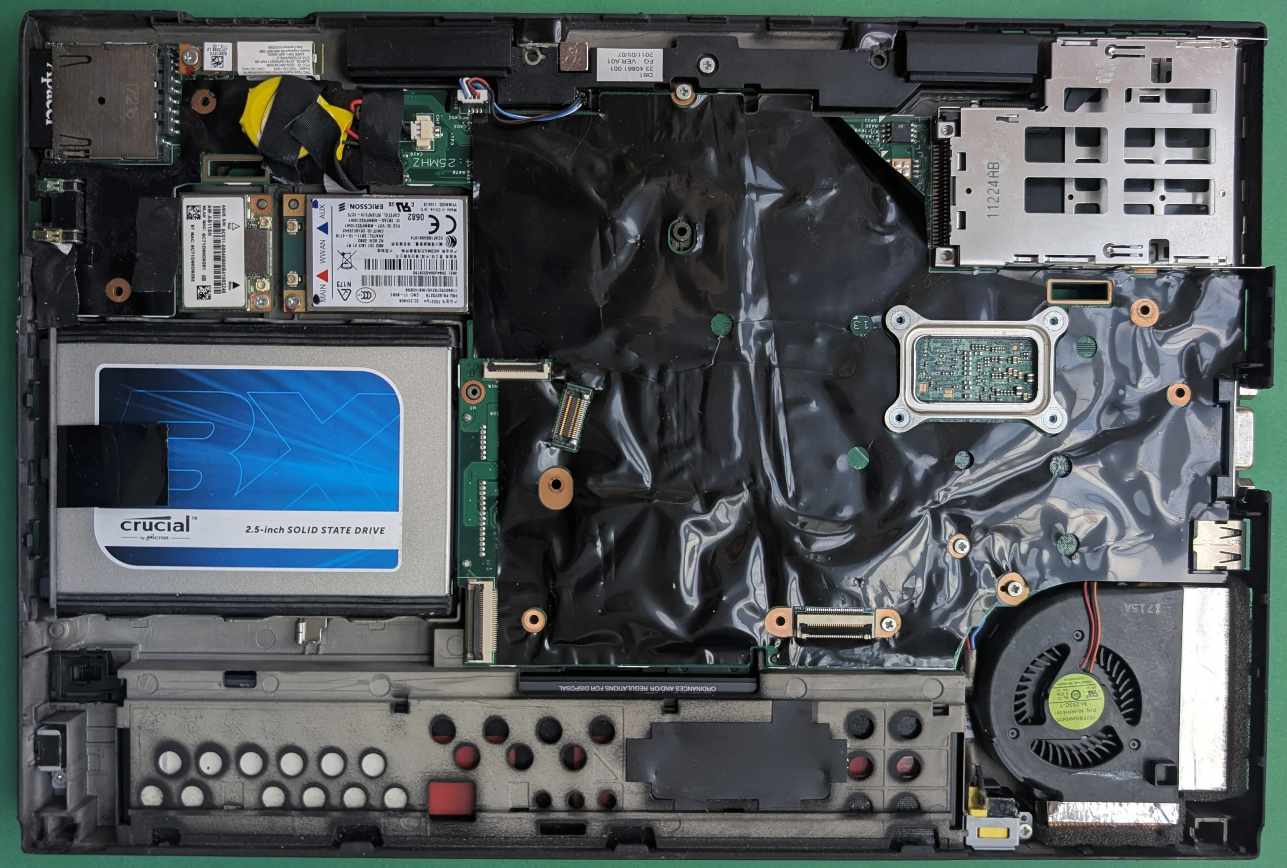 Interior de um notebook Lenovo ThinkPad X220 aberto com SSD, placa-mãe e ventoinha visíveis