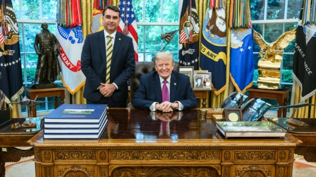 Donald Trump sentado no Salão Oval com Flávio Bolsonaro ao lado durante encontro em maio de 2026